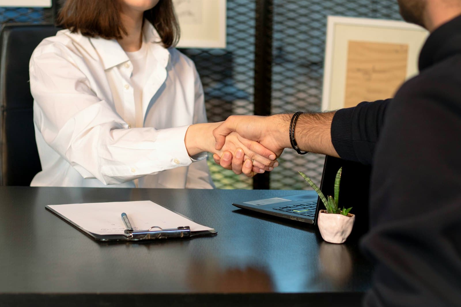 Handshake across a desk during a job interview