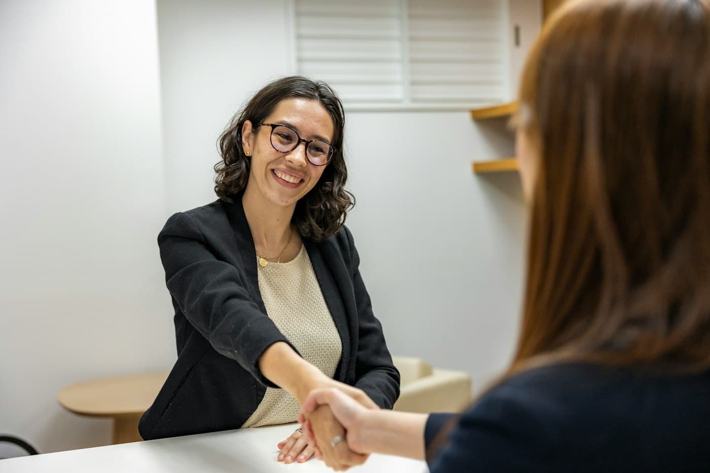 Client shaking hands with a developer after a call answering her software development questions