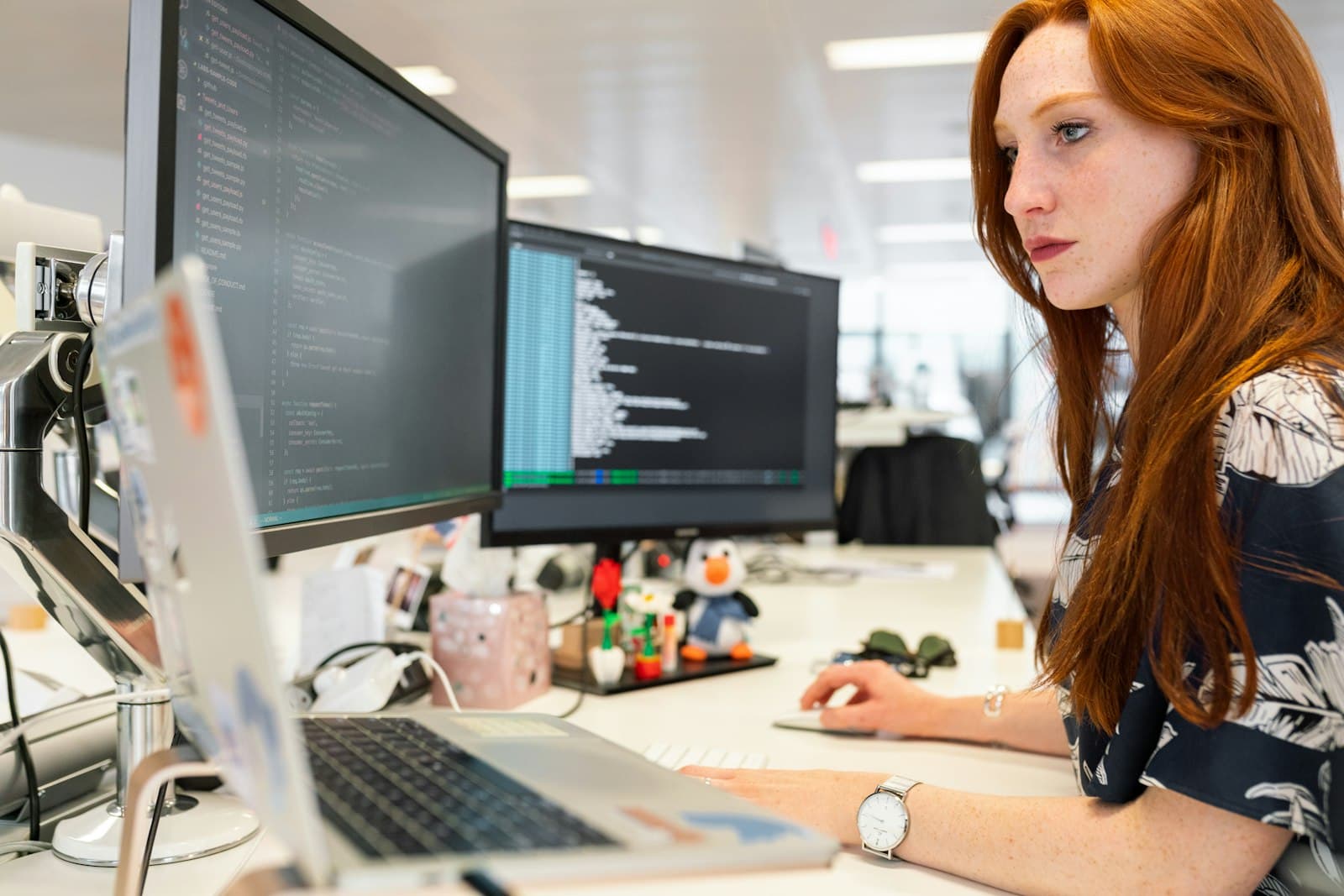 Developer writing code across two monitors