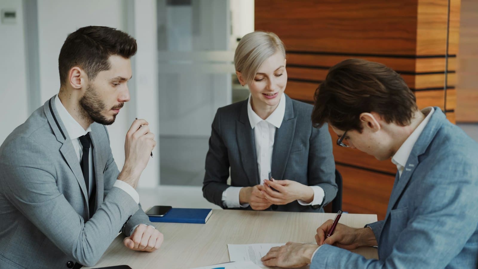 Lawyers meeting with a client who signs a document
