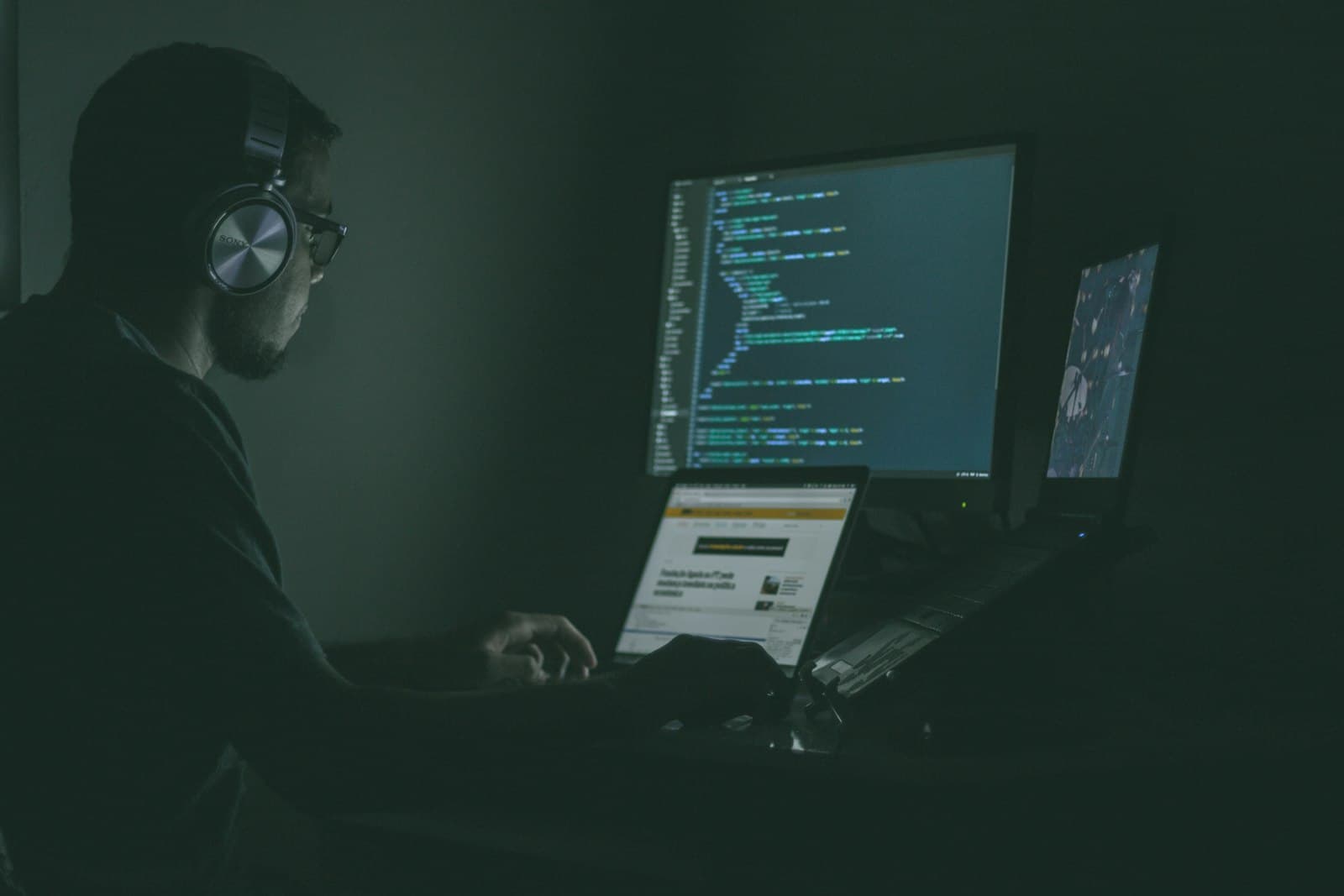 Developer reviewing code across two laptops