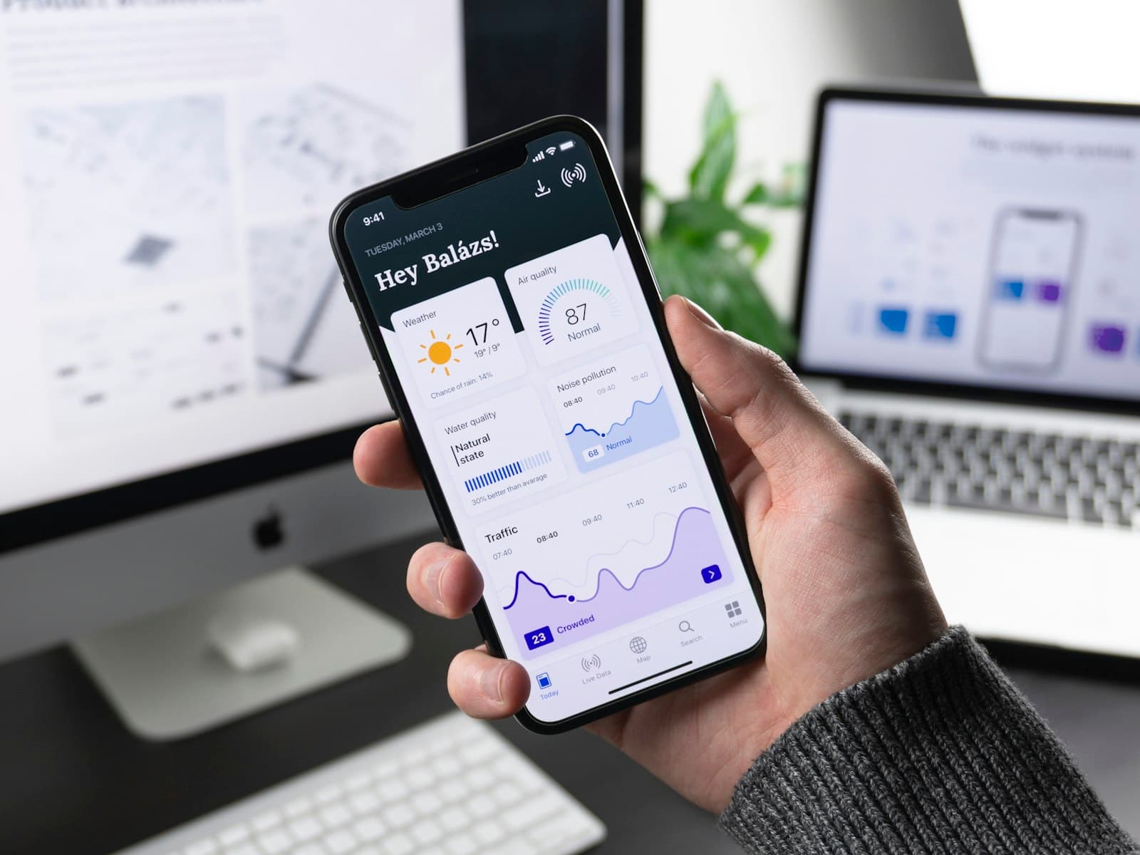 Hand holding a smartphone showing a data dashboard app