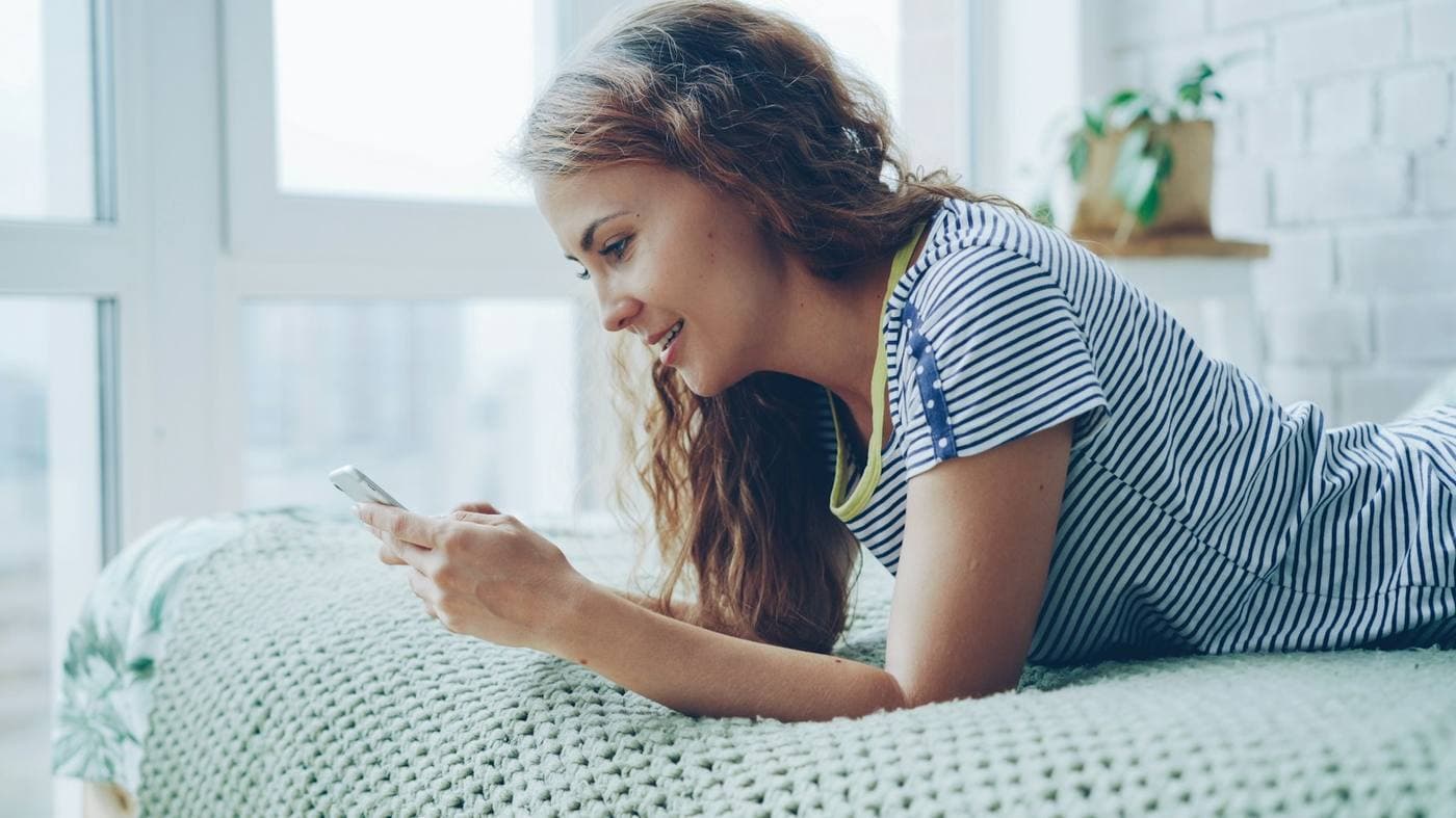 Renter texting an AI leasing assistant from her apartment to book a tour